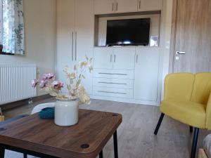 a living room with a table and a yellow chair at Metsovo Fireplace Retreat I in Metsovo