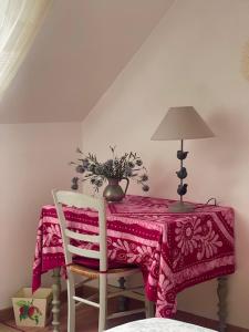 a table with a pink table cloth and a lamp and a chair at Grand Mainguet in Saint-Lambert-la-Potherie +15 photos