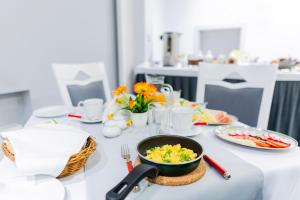 a table with a bowl of food and plates of food at Kamienica Pod Neptunem - Rynek Puck - Śniadanie w cenie - 200m do Molo in Puck