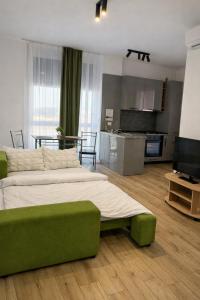 a bedroom with a large green bed and a kitchen at Sika Buzz Premium Apartment - cazare Arad - self check-in in Arad