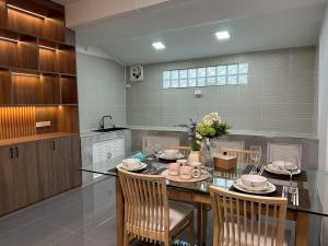 a dining room with a table and chairs in a kitchen at Apples Pattaya Townhouse in Pattaya South +12 photos