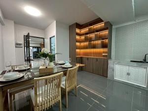 a kitchen with a dining table and chairs and a counter at Apples Pattaya Townhouse in Pattaya South