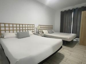 two beds in a room with two beds sidx sidx sidx sidx at Apartamento 1ª linea by Hugo Beach Hotel - Familias in Gandía