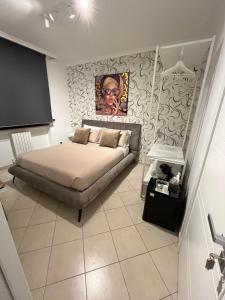 a bedroom with a bed and a painting on the wall at BRUMARI -Design" moderno, self check-in e parcheggio facile in Foggia