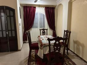 a room with a table and chair in front of a window at Luxor flats and apartments in Luxor +12 photos