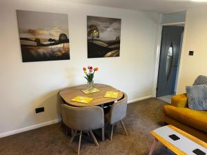 ein Esszimmer mit einem Tisch und einem Sofa in der Unterkunft Witz End in Corsham