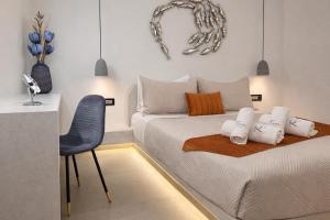 a small bedroom with a bed and a chair at Tiara Suites Fira - Cycladic & Cave in Fira +19 photos