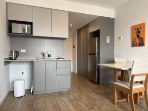 a kitchen with white cabinets and a table at Estudio 63 in Neuquén