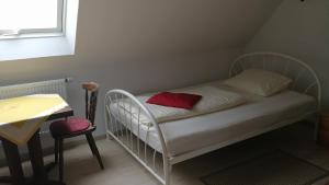 a small bedroom with a bed with a red pillow at Pension Bei Valentina in Wertheim