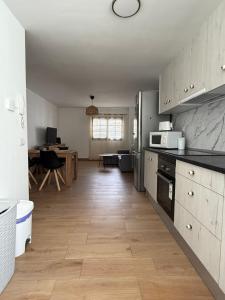 a kitchen with wooden floors and stainless steel appliances at El Puertito Beach Retreat in Agaete