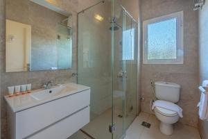 a bathroom with a toilet and a sink and a shower at unique flat_ garden and lagoon in Hurghada +12 photos