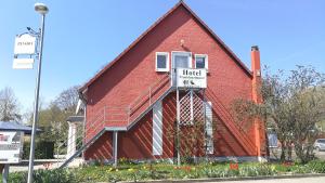 a red house with a sign on the side of it at Pension Bei Valentina in Wertheim