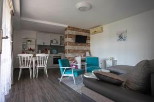 a living room with a couch and a table and chairs at Apartman Marija in Bošnjaci