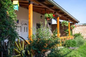 a house with a porch with flowers and plants at Apartman Marija in Bošnjaci