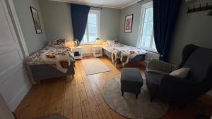 a small room with two beds and a chair at Ranchen B&B in Enköping