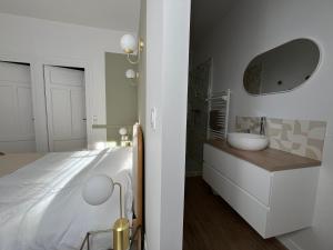 a bedroom with a white bed and a sink at Maison WILSON in Blois