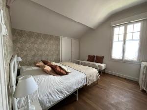 a white bedroom with a bed and a window at Maison WILSON in Blois
