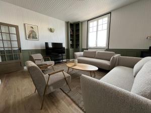 a living room with couches and a tv at Maison WILSON in Blois