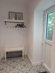 a room with a white wall and a floor with a window at Gastenverblijf Onder een Oude Eik in Tongeren