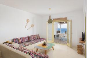 a living room with a couch and a table at Kastella Sunset Villa Three in Kithnos