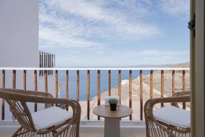 a balcony with chairs and a view of the ocean at Kastella Sunset Villa Three in Kithnos