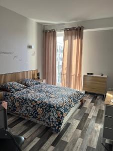a bedroom with a bed and a desk and a window at Appart Cosy Centre ville -proche gare in Châtellerault