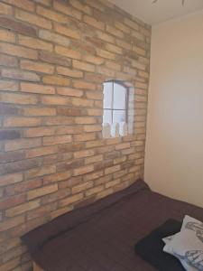 a brick wall in a bedroom with a bed at Apartament Lipowa in Lidzbark