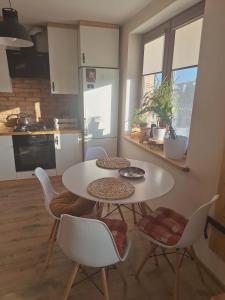 a kitchen with a table and chairs in a kitchen at Apartament Lipowa in Lidzbark