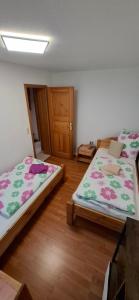 two beds sitting in a room with wooden floors at Donaublick Möhringen in Tuttlingen