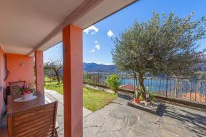 a balcony with a tree and a view of the water at LA TERRAZZA appartamento di vacanza in Collina d'Oro