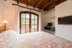 een slaapkamer met een bed en een groot raam bij Cabañas Gonzalez in Villa Gesell
