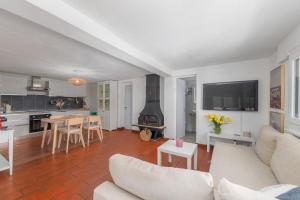 a living room with a couch and a kitchen with a fireplace at LA TERRAZZA appartamento di vacanza in Collina d'Oro