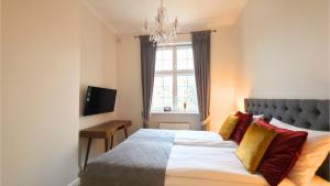 a bedroom with a bed and a chandelier at Old Town Gdansk Olives Marina Apt 2 min walk to Motlawa River in Gdańsk