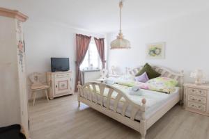 a bedroom with a white bed and a tv at Landhaus Süchterscheid in Süchterscheid