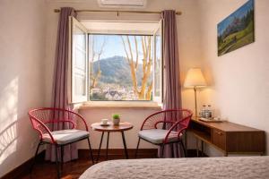 a bedroom with two chairs and a desk and a window at Happy Sintra Inn Guesthouse & Breakfast in Sintra