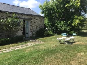a house with a table and chairs in the yard at Grand Mainguet in Saint-Lambert-la-Potherie