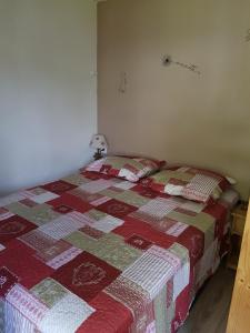 a bedroom with a bed with a quilt on it at Abondance studio la marmotte in Abondance