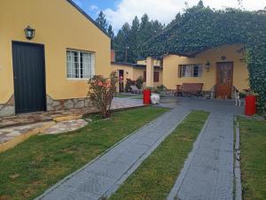 a house with a walkway in front of a yard at Alojamiento Corcovado in El Corcovado