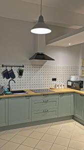 a kitchen with green cabinets and a sink and a light at Dom Wczasowy Centrum Pieniny in Maniowy +63 photos