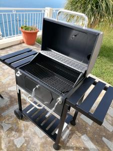 a bbq grill with a laptop on it at The best sea view in Madeira - Casa Farol in Fajã da Ovelha