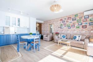 a kitchen and living room with a brick wall at Blue Eye Apartment in Sarandë