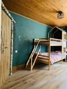 a bedroom with two bunk beds in a wooden ceiling at Gîte de la forêt in Mont-de-Vougney