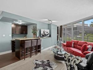 a living room with a red couch and a kitchen at Modern 2BR Luxury Apartment - Amazing Location, Steps To Everything! in Vancouver