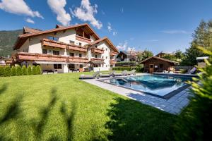 a house with a swimming pool in a yard at Hotel Waldheim in Valle Di Casies
