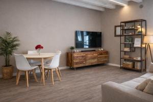 a living room with a table and a tv at La casa ai Laghetti in Montorio Veronese