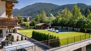 a house with a yard with a swimming pool at Hotel Waldheim in Valle Di Casies
