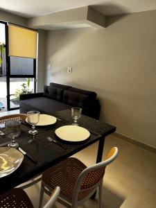 a living room with a black table and chairs at MOTEL LIBIDUS - Foz do Iguaçu in Foz do Iguaçu