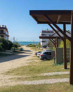 a parking lot with cars parked next to the beach at Terraza Marina V in Pinamar
