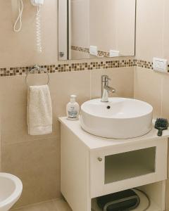 a bathroom with a white sink and a mirror at Terraza Marina V in Pinamar