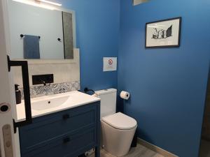 a blue bathroom with a toilet and a sink at Les Casetes in La Senia +49 photos